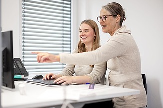 Bild von zwei Frauen, die im einem Büro stehen