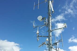 The picture shows a mast with different antennas and radio components