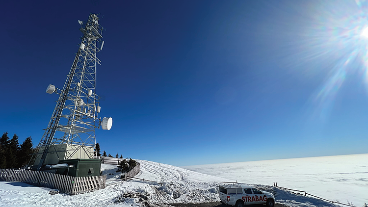 Picture of a mast in a snowy hilly landscape