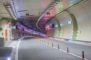 Das Bild zeigt den bunt beleuchteten Tunnel von slowenischer Seite kommend