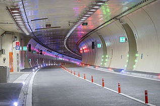 The picture shows the colorfully illuminated tunnel coming from the Slovenian side