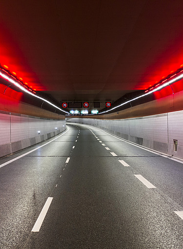 Image of an empty road tunnel with red and green LED lighting