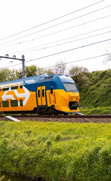 The picture shows a train of the Dutch rail operator Nederlandse Spoorwegen N.V