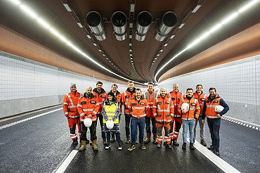 Bild von einer Mannschaft in Arbeitskleidung mittig in einem leeren Tunnel
