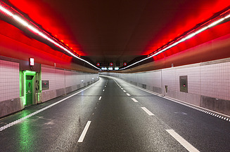 Image of a tunnel with red ceiling lighting and signs