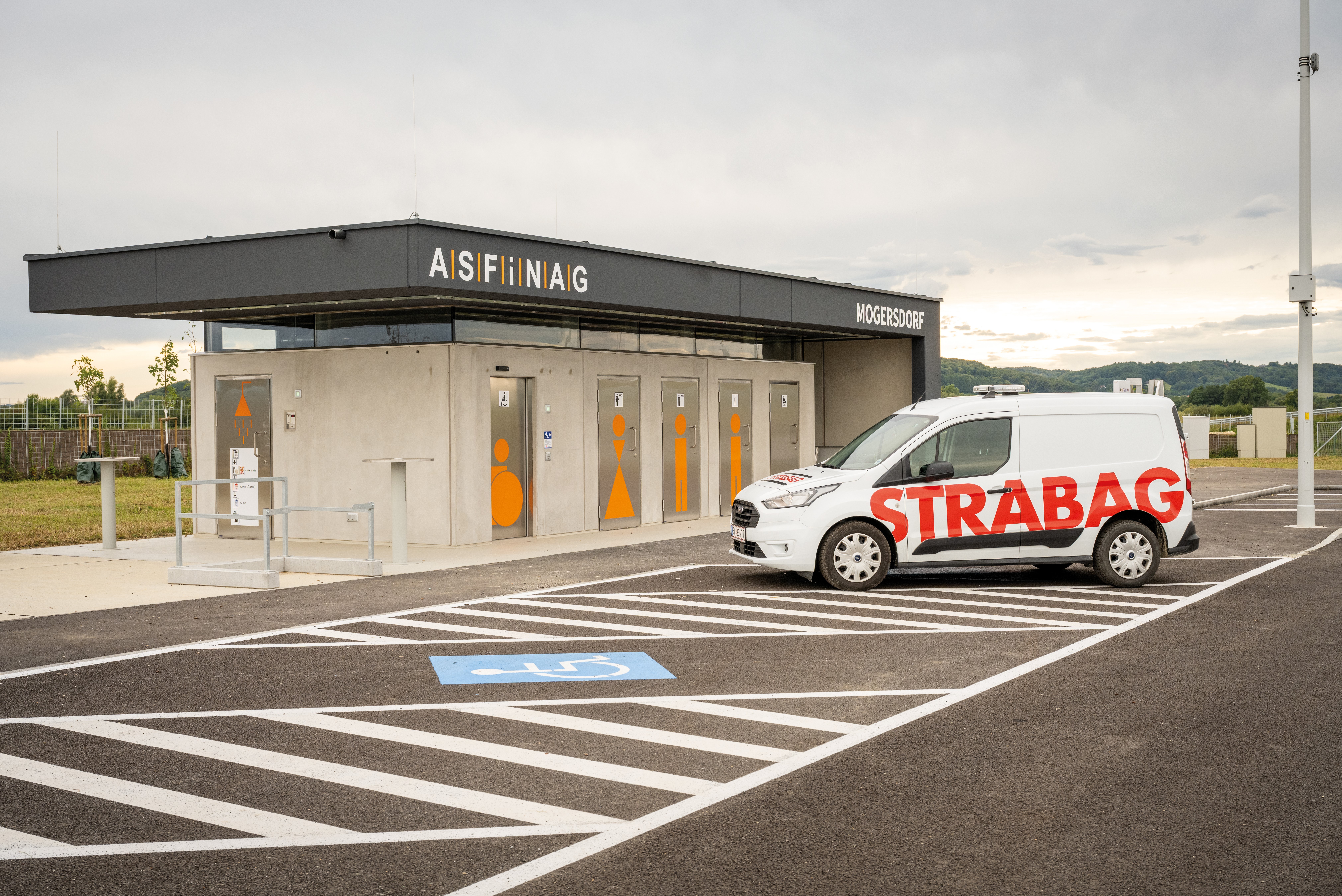 The image shows a STRABAG service vehicle at an ASFiNAG rest area